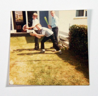 Polaroid photo of three children with ball game equipment