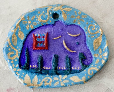 A purple elephant on a blue and gold dish