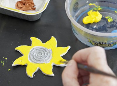 Painting a clay sun yellow