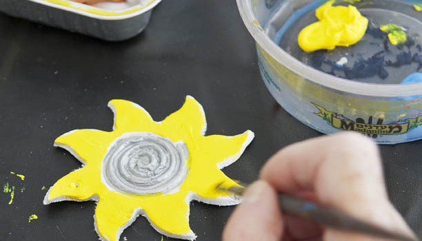 Painting a clay sun yellow