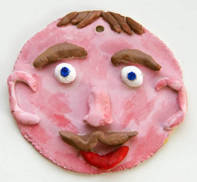 Painted clay face of man with moustache