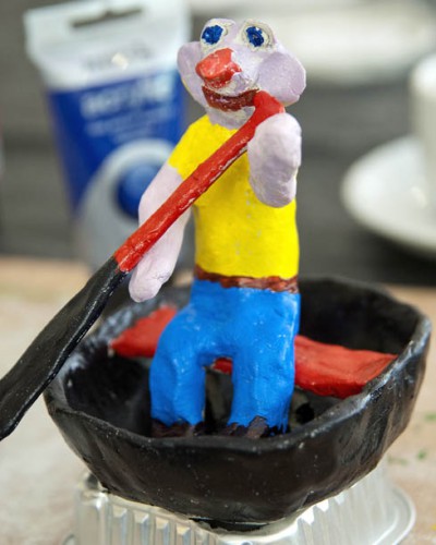 A painted clay figure in a boat