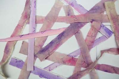 Brown and purple strips of fabric with writing on