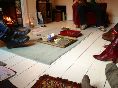 Photo of 5 people's feet while they sit around a sitting room