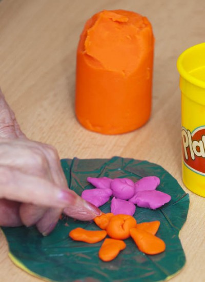 A person making a Play Doh lily pad